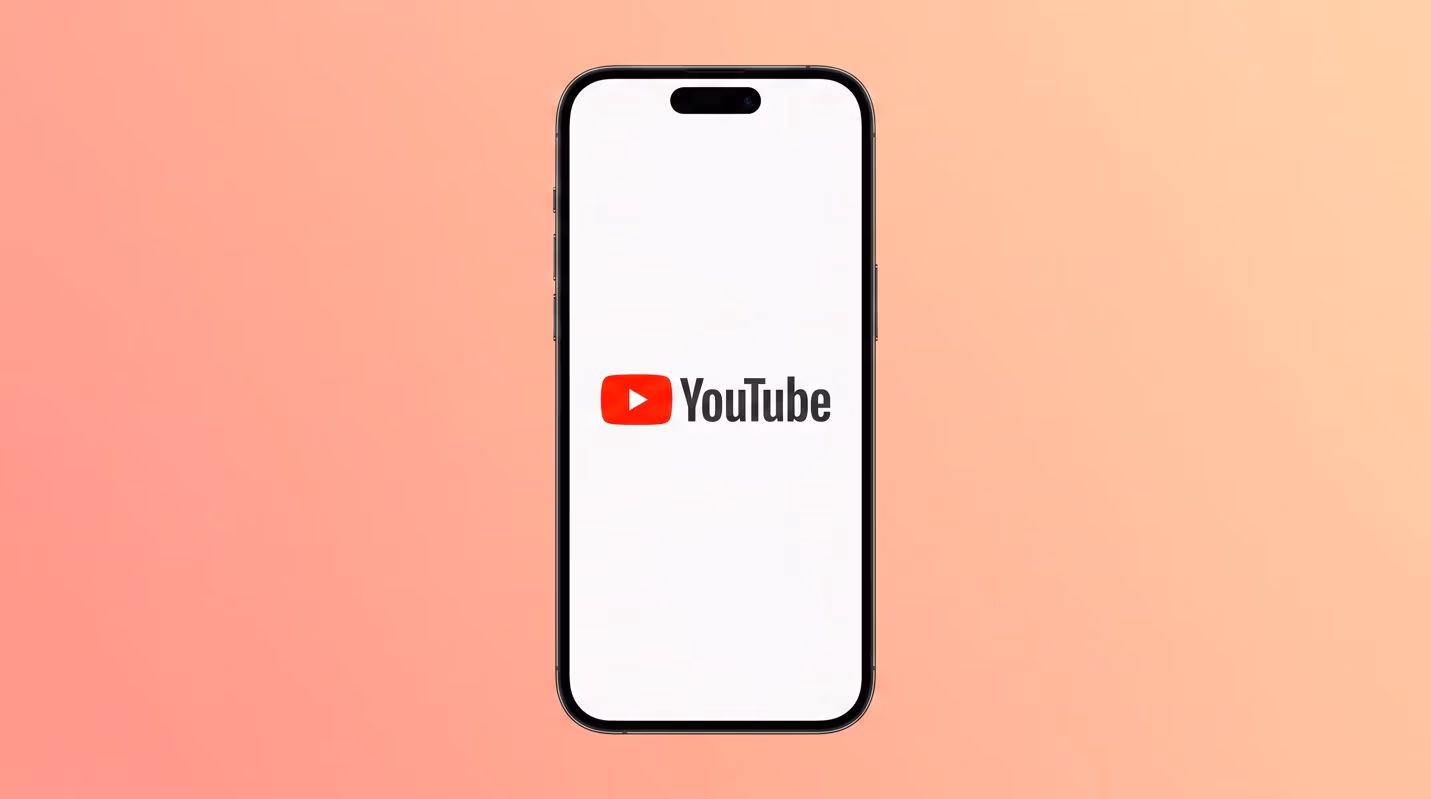 Photo-style graphic of a smartphone displaying the YouTube logo (red play button and wordmark) centered against a pink-to-orange gradient background.